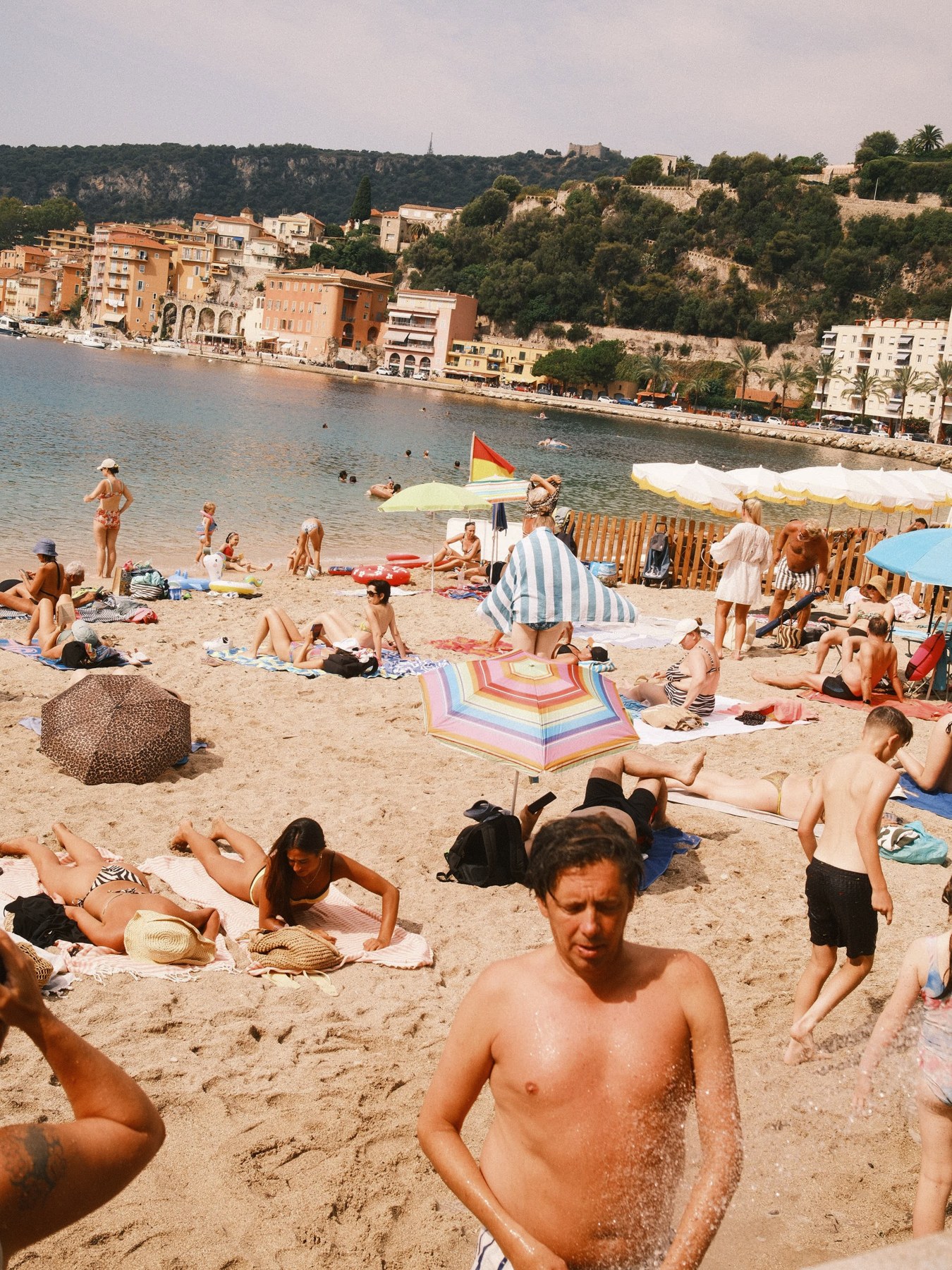 A crowded beach and sunlit shoreline.