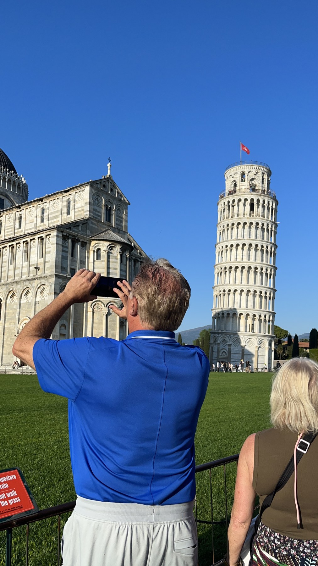 A visitor photographing the Leaning Tower of Pisa.